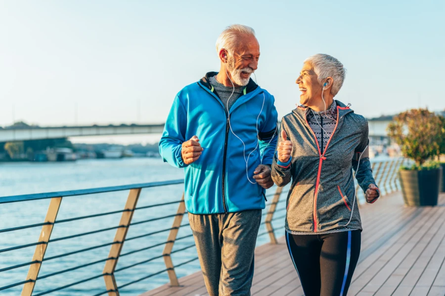 A senior couple jogging on a deck by the lake