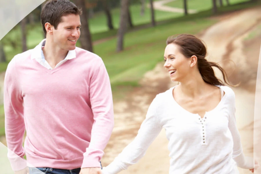 Couple walking together while holding hands and smiling